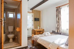 ein Schlafzimmer mit einem Bett und ein Badezimmer mit einer Toilette in der Unterkunft Casa Elder Villa in Bran + 97 Fotos