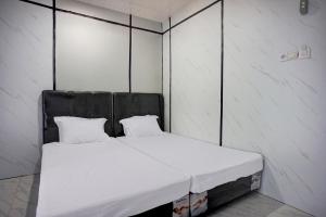 een bed met twee kussens erop in een kamer bij OYO 94903 Akasia Guesthouse in Perbaungan