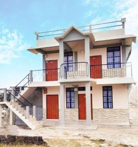 a house with red doors on a beach at Sunny Ridge Homesty in Cherrapunji