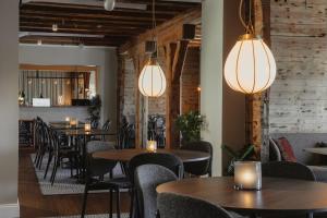 a restaurant with tables and chairs and lights at Home Hotel Packhuset in Kalmar