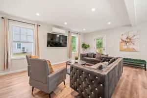 a living room with a couch and chairs and a tv at Ideal Family Stay Sleeps 20 in Bloomfield, CT in Bloomfield