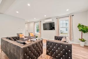 a living room with two couches and a tv at Ideal Family Stay Sleeps 20 in Bloomfield, CT in Bloomfield