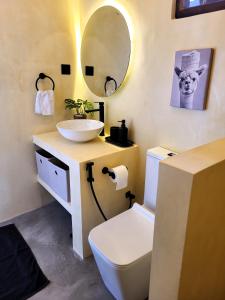 a bathroom with a sink and a toilet and a mirror at Kalavida - 2 Mins walk to Kabalana Beach in Piyadigama