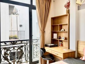 a room with a balcony with a desk and a window at Four P Home in Ho Chi Minh City