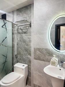 a bathroom with a toilet and a sink and a mirror at Four P Home in Ho Chi Minh City +44 photos