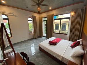 a bedroom with a bed and a table and windows at Tam Coc HaVi's Hotel - Restaurant in Văn Lâm