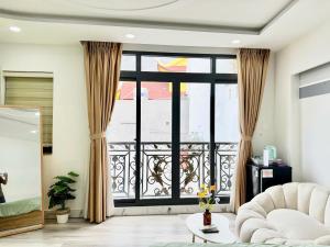a living room with a couch and a large window at Four P Home in Ho Chi Minh City