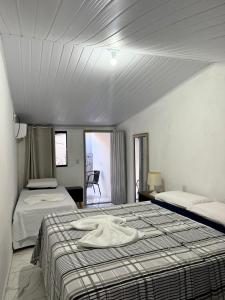 a bedroom with two beds with towels on it at A casa roxinha in Lençóis
