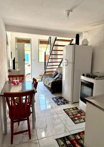 a kitchen and living room with a refrigerator and a table at A casa roxinha in Lençóis