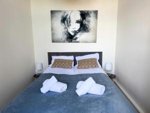 Un dormitorio con una cama con dos almohadas y un cuadro. en Zapisane w Cegle 2 by LibertaRent, en Świdnica