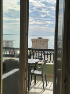 a balcony with a table and chairs and the ocean at Attico Galilei Fronte Mare by Salentoville Gallipoli in Gallipoli