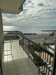 a balcony with a view of a parking lot and the ocean at Attico Galilei Fronte Mare by Salentoville Gallipoli in Gallipoli