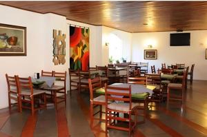 a dining room with tables and chairs and a tv at Cavalinho Branco 309 in Águas de Lindóia