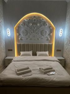 a bedroom with a large bed with two towels on it at Hotel LION Almaty in Almaty