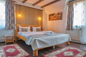 ein Schlafzimmer mit einem Bett und einem großen Fenster in der Unterkunft Casa Elder Villa in Bran