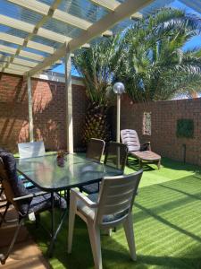 a patio with a table and chairs on a lawn at Yarrawonga Holiday Unit in Yarrawonga