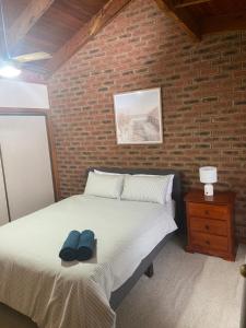 a bedroom with a bed with a brick wall at Yarrawonga Holiday Unit in Yarrawonga