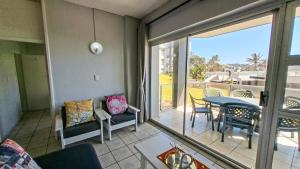 ein Wohnzimmer mit einem Balkon mit einem Tisch und Stühlen in der Unterkunft Seagull 204 in Margate