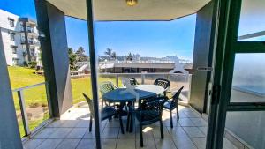 ein Tisch und Stühle auf einem Balkon mit Blick auf das Meer in der Unterkunft Seagull 204 in Margate