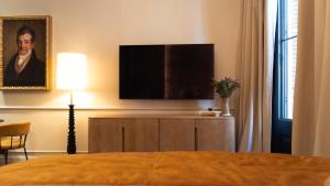 a bedroom with a flat screen tv on a cabinet at Boada Riera - The RoomsbyReini in Terrassa