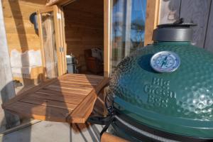 EbberstonにあるThe Hygge Out - Glamping Site in North Yorkshireの木のテーブルの横に置かれた大きな緑色の瓶