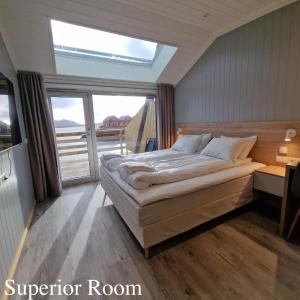 a bedroom with a large bed and a window at Lofoten Basecamp in Leknes