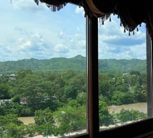 a window with a view of trees and a river at Hotel Crystal Ganga Heights 5 Min from Har Ki Pauri in Haridwār