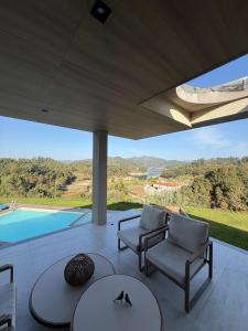une terrasse avec des chaises, une table et une piscine dans l'établissement Quinta dos Anjos - Guilhofrei, à Guilhofrei