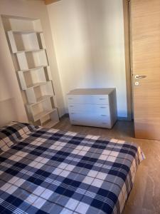 a bedroom with a bed and a dresser and a door at Appartamento Ambro in Tione di Trento