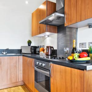 una cucina con armadi in legno e un piatto di frutta di Stylish Apartment - Private Parking - Balcony - Chinatown - 49Arc a Birmingham