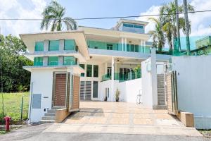 een wit huis met palmbomen ervoor bij Serene Pool Villa -Luxury Stay with Relaxing Vibes -Clover Home in Kajang