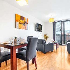 un soggiorno con tavolo, sedie e divano di Stylish Apartment - Private Parking - Balcony - Chinatown - 49Arc a Birmingham