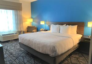 a hotel room with a large bed and a blue wall at SureStay by Best Western Cambridge in Cambridge