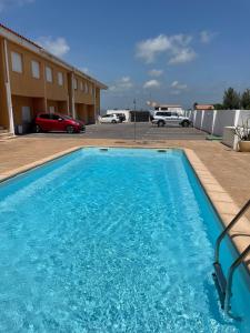 Una gran piscina azul en un estacionamiento. en Getaway with views of the rice fields Relax and beach, en Els Muntells