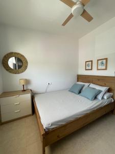 Un dormitorio con una cama y un ventilador de techo. en Getaway with views of the rice fields Relax and beach, en Els Muntells