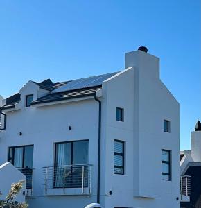 a white building with a solar roof on it at 6 on Third in Stompneusbaai
