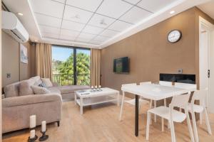 a living room with a couch and a table at Demirel Suites Antalya-Lara Plajlar ve Havalimanına Yakın in Lara