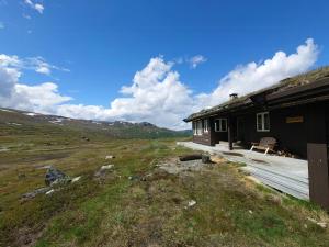 a house with a deck next to a mountain at Renovated Mountain Cabin With Cross Country Trails in Granheim