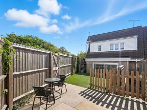 a patio with chairs and a table next to a fence at Lovely 2-Bed House with parking in Broomfield