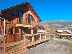 a large wooden house with a deck and mountains at Chalet Martina in Stadl an der Mur