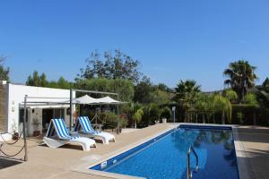 Una piscina con tumbonas al lado de una casa. en St.George's Country Retreat, en Limassol