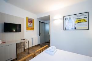 a living room with a table and a tv and a room at Albergo Giardino in Cernobbio