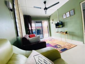 a living room with a couch and a tv at Asu Homestay w Private Pool - Batu Gajah,Perak in Batu Gajah