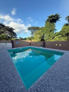 a swimming pool with blue water in front of a fence at Asu Homestay w Private Pool - Batu Gajah,Perak in Batu Gajah