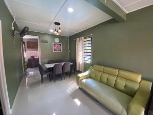 a living room with a couch and a table at Asu Homestay w Private Pool - Batu Gajah,Perak in Batu Gajah