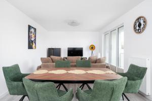 una sala da pranzo con un tavolo e sedie verdi di Widzewska Prime Apartments by BookingHost a Łódź