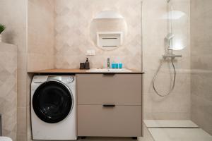 un bagno con lavatrice e lavandino di Widzewska Prime Apartments by BookingHost a Łódź Altre 44 foto