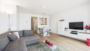 コクセッドにあるMalouki Koksijde - 4 star appartment with magnificent sea viewのソファとテレビのあるリビングルーム