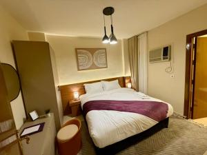 a hotel room with a large bed and a window at D3S 3BR Apartment in Makkah