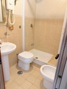 ein Badezimmer mit Toilette, Waschbecken und Dusche in der Unterkunft Hotel Bruna in Rom